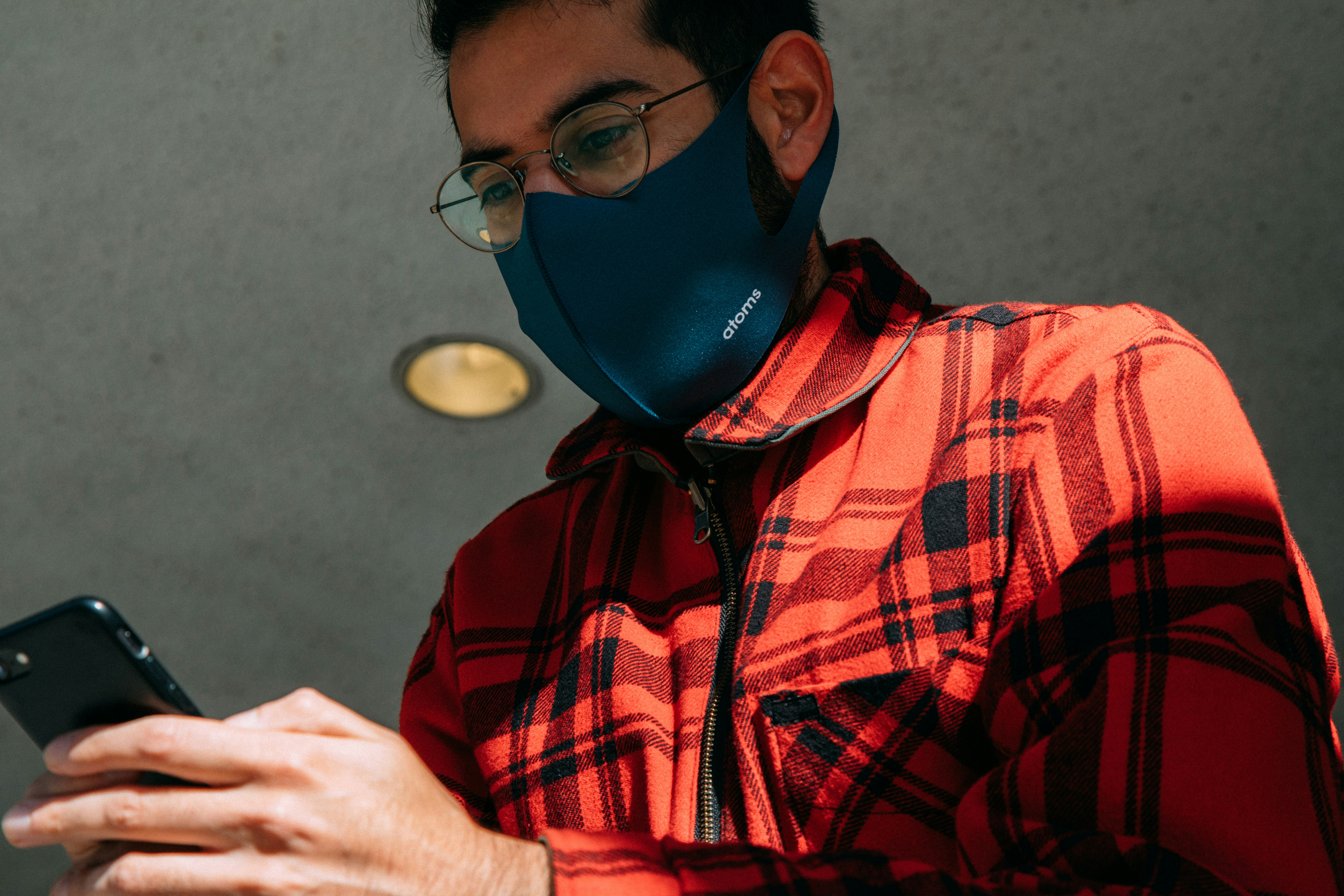 man in red and black plaid button up shirt wearing blue mask